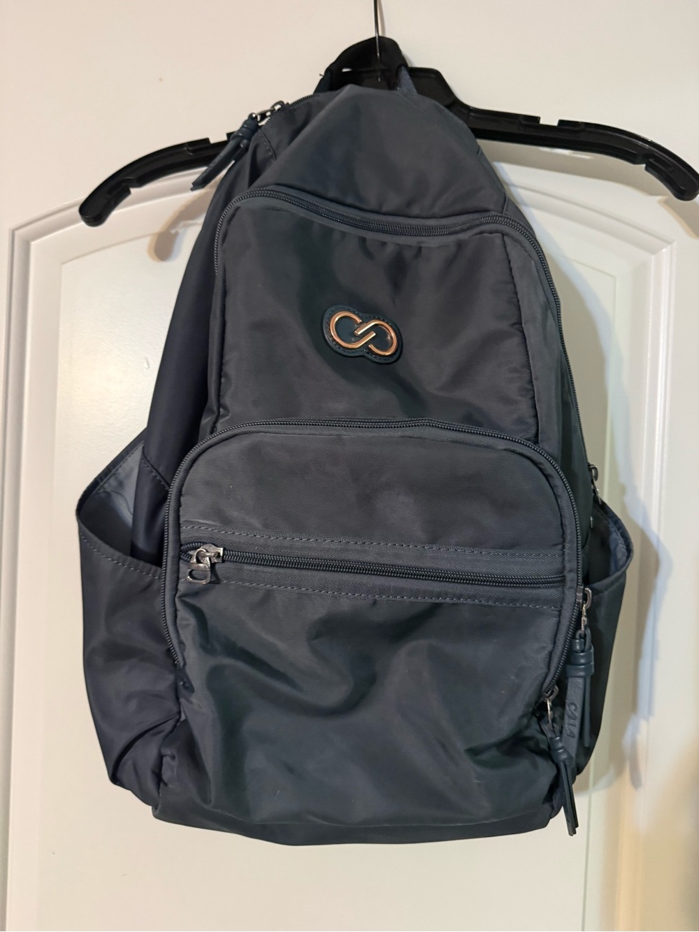 CALIA by Carrie Underwood Black Sling Backpack with Rose Gold Accent